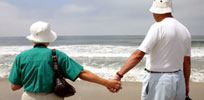 senior couple holding hands on the beach